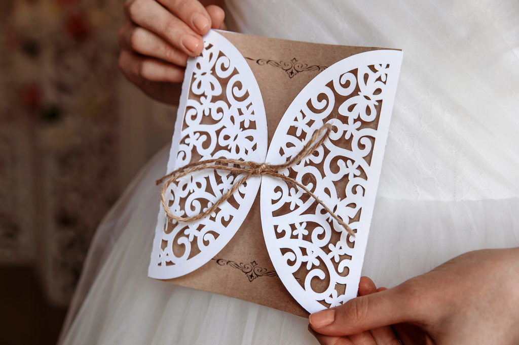 Wedding invitation card in hands in rustic style